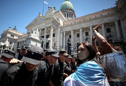 La tensión entre la policía y los manifestantes no tardó en encenderse. Sobre la una de la tarde de Buenos Aires, mientras un grupo de personas gritaba frente al Congreso en contra de la ley de Milei, agentes federales despejaron la concentración a los empujones para desbloquear un carril de la calle Callao para que pasen los coches. En la imagen, policías y manifestantes frente al Congreso. 