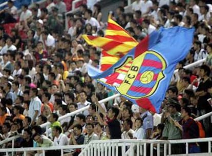 Seguidores chinos contemplan el entrenamiento del Barça ayer en Pekín.