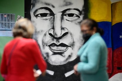 Dos mujeres votan frente a un mural de Hugo Chávez en un centro de votación de Caracas. 