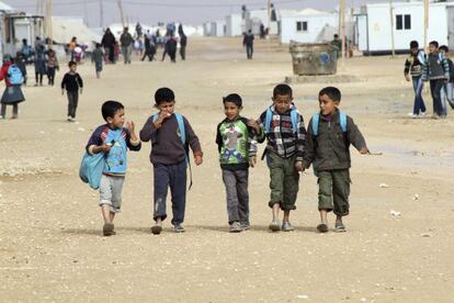 Niños sirios van junto al colegio del campo de refugiados de Mafraq, Jordania.