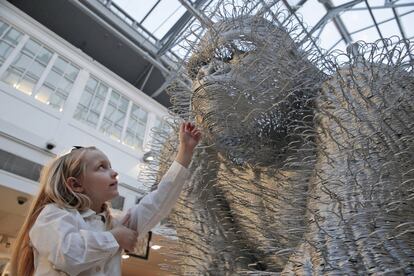 Una niña toca una escultura que representa a un gorila titulado 'Silver Back' del artista David Mach, durante la presentación de una subasta temática que presenta el animal como fuente de inspiración artística, titulado 'Criaturas grandes y pequeñas ", en Londres.