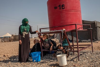 Una mujer de Homs desplazada en el campamento de Al Alsadya, cerca de la ciudad de Raqa, llena un cubo en el tanque del campamento, la única fuente de agua disponible.