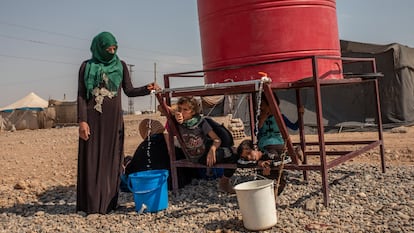 Una mujer de Homs desplazada en el campamento de Al Alsadya, cerca de la ciudad de Raqa, llena un cubo en el tanque del campamento, la única fuente de agua disponible.