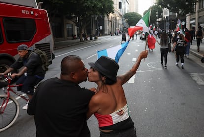 Alex Navas y Jackie se besan mientras marchan contra redadas migratorias federales en el centro de Los Ángeles.