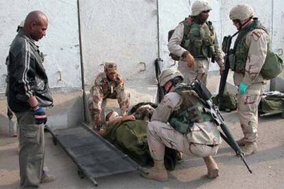 Médicos del Ejército de EE UU atienden a un policía iraquí herido tras un atentado con coche bomba el sábado en el centro de Bagdad.