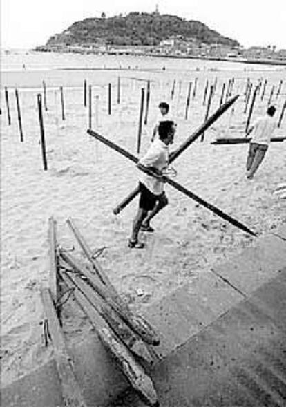 Trabajos de instalación de los quitasoles de las playas donostiarras.