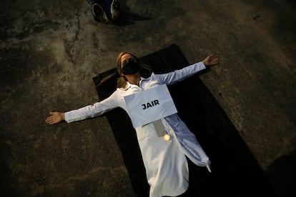 Enfermeira protesta com cartaz em que se lê "Jair", nome de um dos profissionais de saúde mortos pelo coronavírus no Brasil, na segunda.