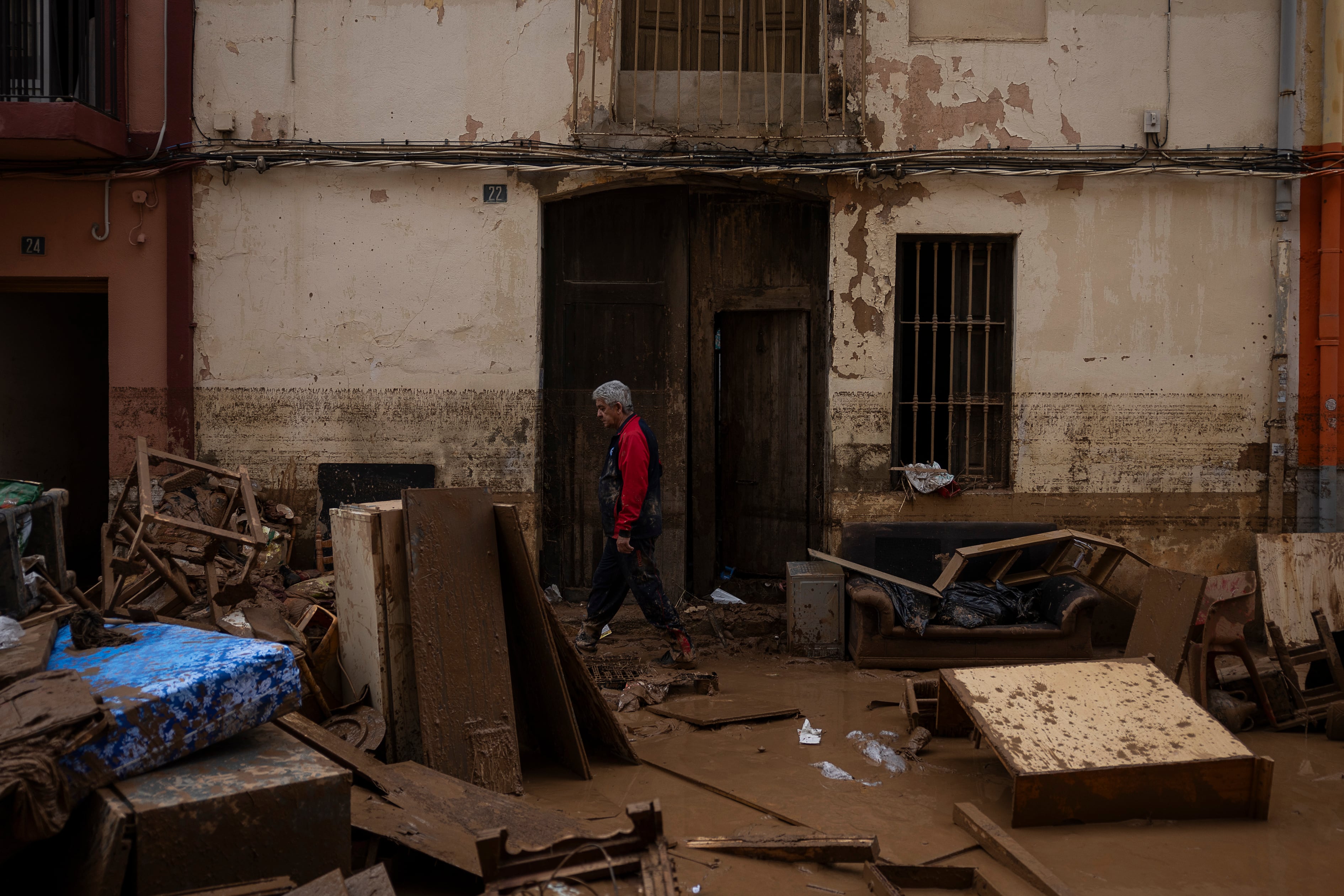 Un hombre camina por una calle que quedó inundada, el jueves en el centro de Aldaia.


