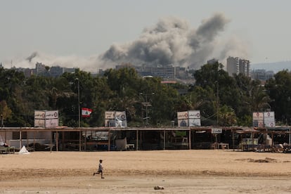 A child runs as smoke billows in the background over southern Lebanon following an Israeli strike, amid ongoing cross-border hostilities between Hezbollah and Israeli forces, as seen from Tyre, Lebanon September 25, 2024.