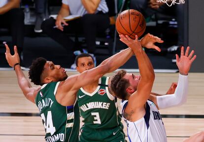 Doncic lanza, obstaculizado por Antetokounmpo.