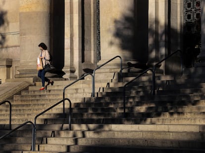 Una mujer baja la escalinata de la entrada de la sede central de Correos en Barcelona.