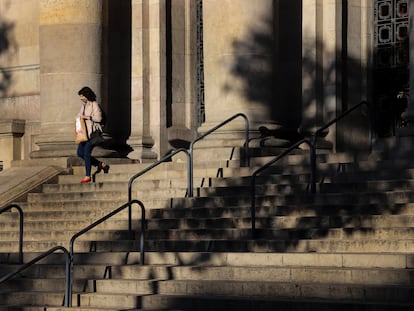 Una mujer baja la escalinata de la entrada de la sede central de Correos en Barcelona.