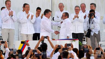 El presidente de Colombia, Juan Manuel Santos, le da la mano a Rodrigo Londoño, alias Timochenko, líder de las FARC, tras la firma del primer acuerdo.