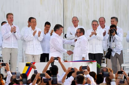 O presidente da Colômbia, Juan Manuel Santos, aperta a mão de Rodrigo Londoño, o Timochenko, líder das FARC, depois da assinatura do acordo final.