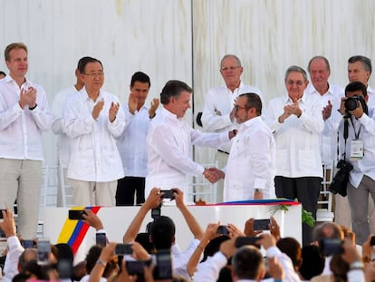 El presidente de Colombia, Juan Manuel Santos, le da la mano a Rodrigo Londoño, alias Timochenko, líder de las FARC, tras la firma del primer acuerdo.