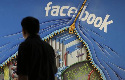 Un hombre camina junto a un mural en el campus de Facebook en Menlo Park, Calif.