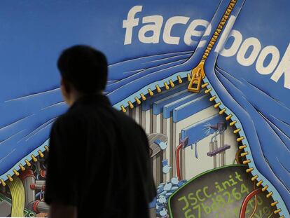 Un hombre camina junto a un mural en el campus de Facebook en Menlo Park, Calif.