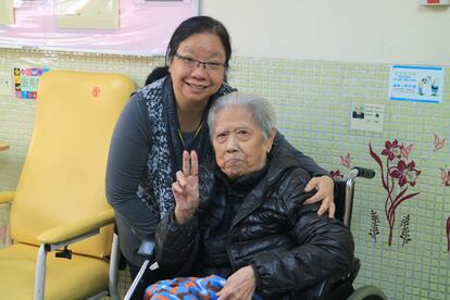La señora Chan (sentada) con una de las trabajadoras de una residencia de cuidados paliativos en Hong Kong