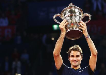 Roger Federer alza su trofeo como ganador del Torneo de Basilea 2015 frente a Rafael Nadal.