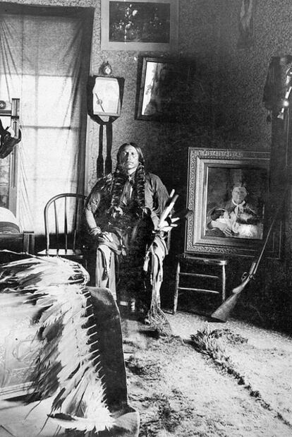 Quanah en su dormitorio, hacia 1897. A su izquierda, el retrato enmarcado de su madre,  Cynthia Ann, y su hermana, Flor de la Pradera.