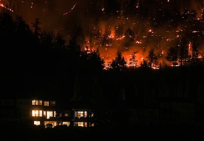 El incendio de McDougall Creek, Canadá, avanzaba por la ladera de una montaña por encima de una casa, el viernes. 