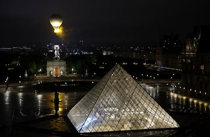 Un globo con la llama olímpica sobrevuela París sobre el Louvre.
