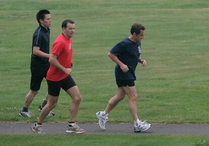 Cumbre de los países ricos en Japón, G- 8. El presidente de Francia Nicolas Sarkozy, corre seguido por sus guardaespaldas en un campo de golf en Toyako