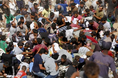 Una multitud de personas intenta conseguir alimento lanzado en cargamentos desde el aire en Deir al Balah, en el centro de la Franja, este viernes 22 de agosto.