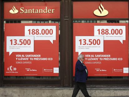 Un hombre camina frente a un banco Santander