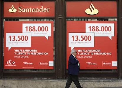 Un hombre camina frente a un banco Santander