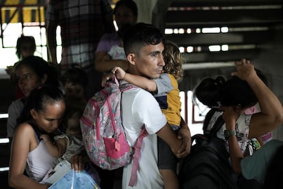 Uno hombre desplazado carga a un niño en sus brazos mientras espera para registrarse como víctima de desplazamiento forzado en el Estadio General Santander, en Cúcuta, el 23 de enero de 2025.