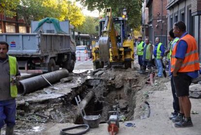 Un grupo de operarios trata de arreglar la rotura de una tubería en el paseo Reina Cristina para restablecer el suministro de agua en el barrio.