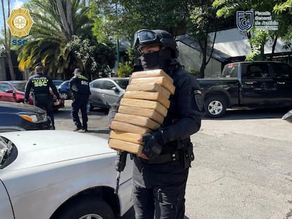 Un oficial de policía carga algunos de los paquetes de cocaína incautados el 26 de julio de 2022, en Ciudad de México.