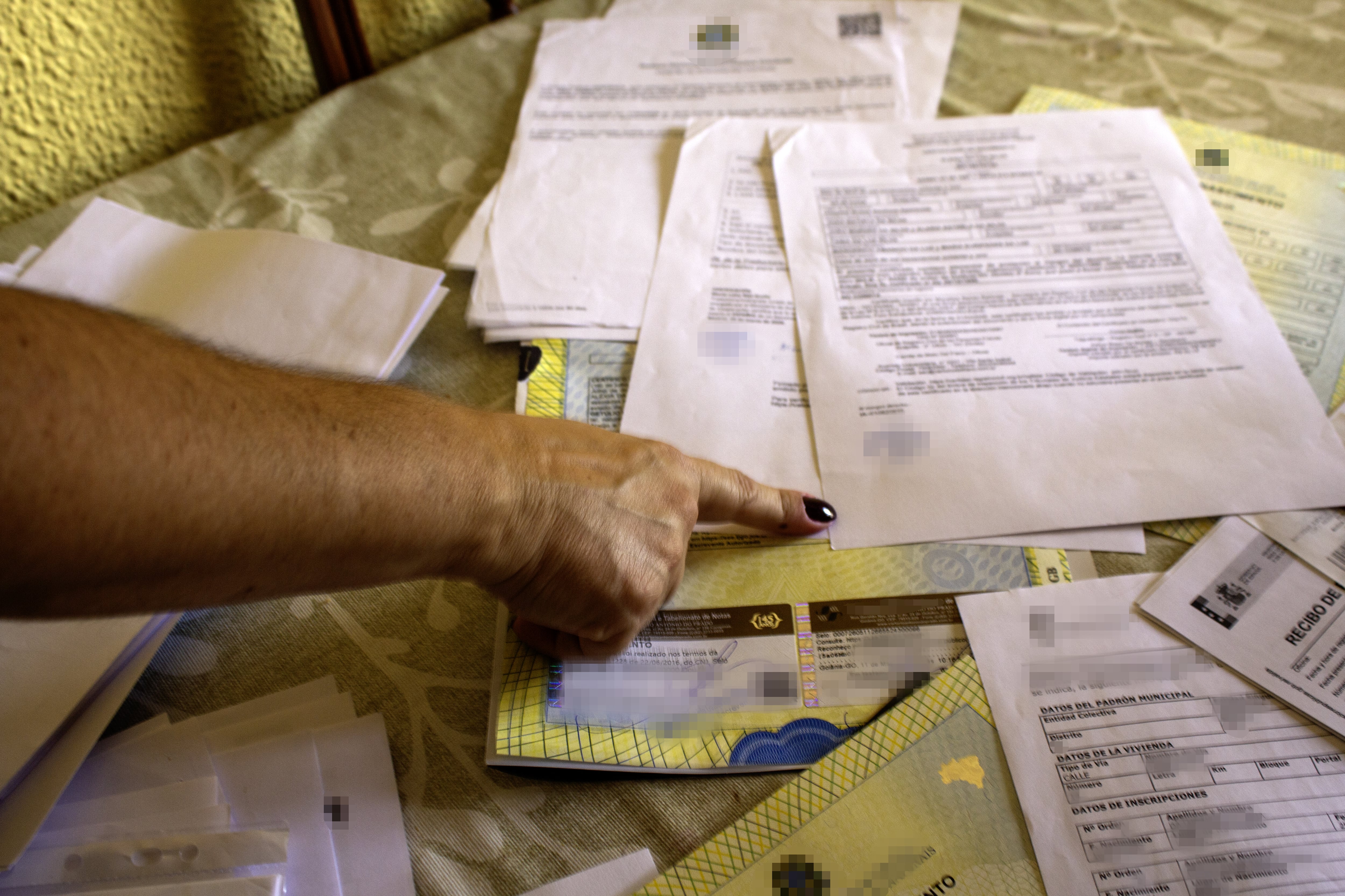Belén señala en su casa los documentos presentados para la regularización extraordinaria.