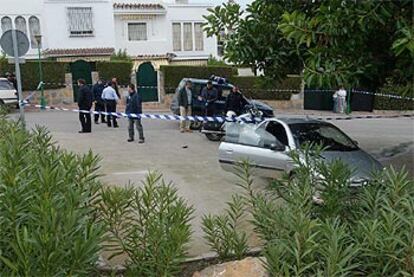 Las policías locales y nacionales acordonan la zona donde se ha producido el tiroteo, con el coche del policía herido.