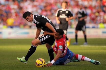 El centrocampista del Real Madrid James Rodriguez pelea un bal&oacute;n con  el delantero del Granada Jeison Murillo.