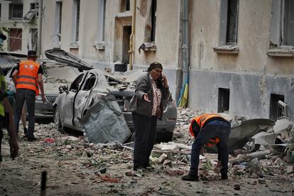 A woman speaks on a phone next to the rubble of the Lviv residential buildings hit by a Russian air strike on July 6.