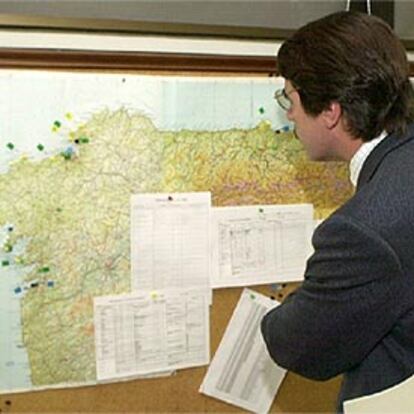 Aznar contempla, en la sala de la torre de control marítimo de A Coruña, la zona del desastre.