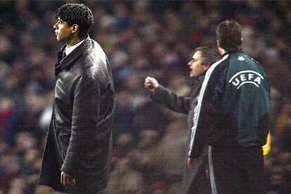 Rijkaard, el cuarto árbitro y, tras él, Mourinho en la banda del Camp Nou durante el partido.