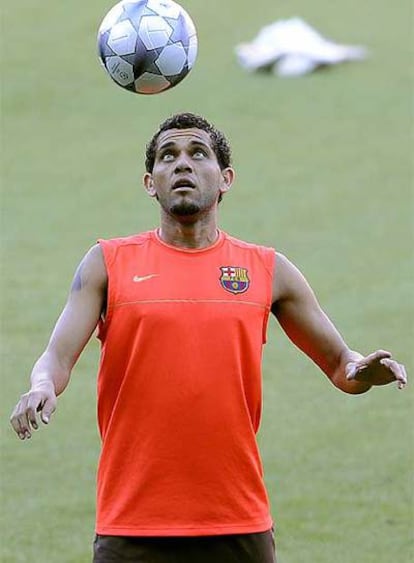 Dani Alves hace malabarismos con el balón durante el entrenamiento de ayer del Barcelona.