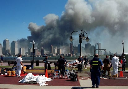 El humo que se originó tras los atentados contra las Torres Gemelas se podía ver a kilómetros de la luego bautizada como 'zona cero'. En la imagen, personal de emergencia atiende a heridos en Liberty Park, Nueva Jersey. La economía estadounidense entró en recesión en 2001, mientras aumentaba la inseguridad y la desconfianza en la seguridad de Occidente.