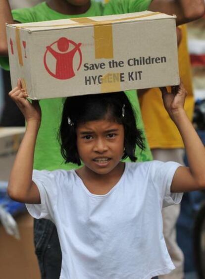 Una niña transporta una caja con ayuda de emergencia en la ciudad de Pariaman, en la isla de Sumatra.