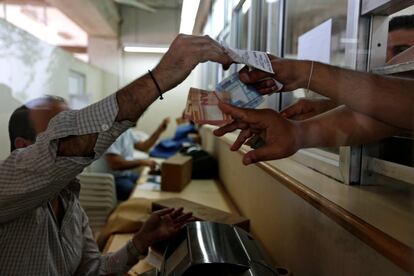 A cashier hands a betting slip to a racegoer at Beirut Hippodrome, Lebanon, May 14, 2017. REUTERS/Jamal Saidi  SEARCH "SAIDI HIPPODROME" FOR THIS STORY. SEARCH "WIDER IMAGE" FOR ALL STORIES.