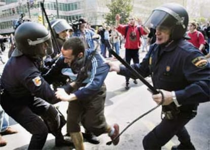 Miembros de la policía antidisturbios detienen a un joven en el transcurso de los altercados originados en el Paraninfo de la Universidad de Zaragoza entre estudiantes y miembros de la Policía Nacional.