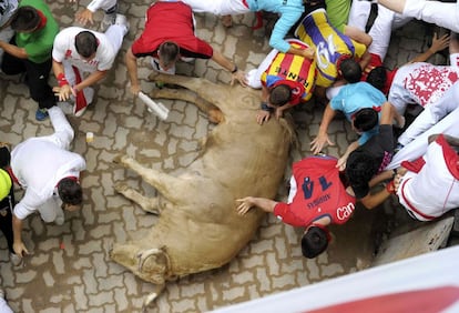 Varios mozos pasan apuros ante los toros de la ganadería de Fuente Ymbro en la entrada al callejón de la plaza de toros de Pamplona.