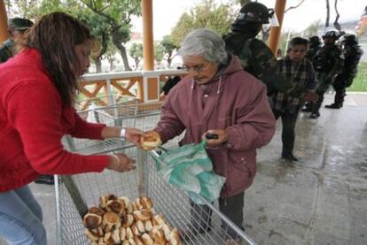 Una ciudadana boliviana se abastece de pan en uno de los puestos que el Ejército ha habilitado en La Paz apra evitar su escasez en los mercados y su alza de precio, según ordenó el presidente Evo Morales.