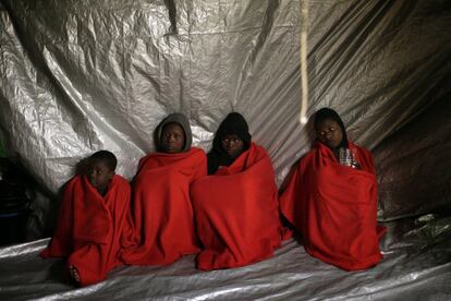Varias inmigrantes subsaharianas descansan en la cubierta del barco Golfo Azzurro después de ser rescatadas de una patera por miembros de la ONG Proactive Open Arms, en el mar Mediterráneo, a unos 24 kilómetros al norte de Sabratha (Libia).
