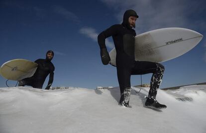 Surferos en la playa de Rockaway, cubierta de nieve, en Nueva York, Estados Unidos.