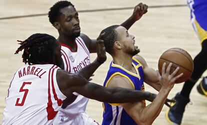 Curry lanza, entre Harrell y Beverley.