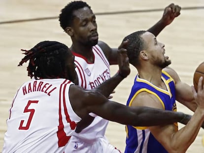 Curry lanza, entre Harrell y Beverley.
